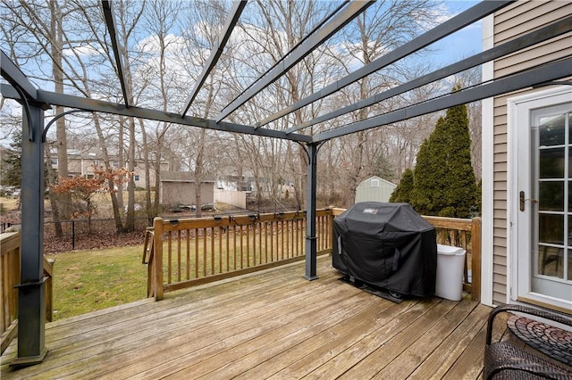 wooden terrace with an outdoor structure, fence, grilling area, a pergola, and a shed