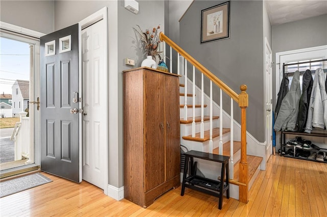 foyer featuring hardwood / wood-style flooring, baseboards, and stairway