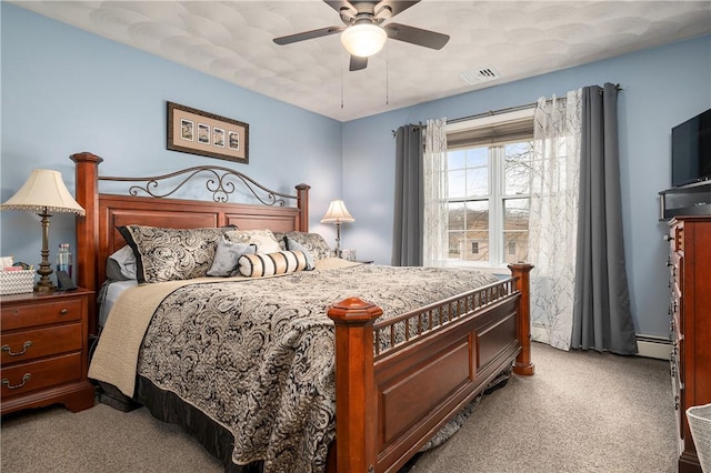 carpeted bedroom featuring a ceiling fan, visible vents, and baseboard heating