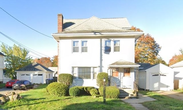 view of front facade with an outbuilding, a front lawn, and a chimney