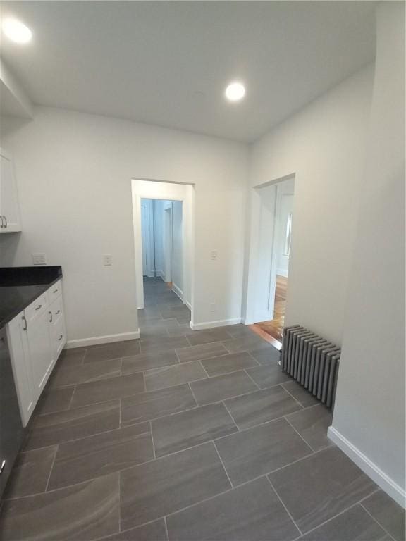 hall featuring radiator heating unit, recessed lighting, and baseboards