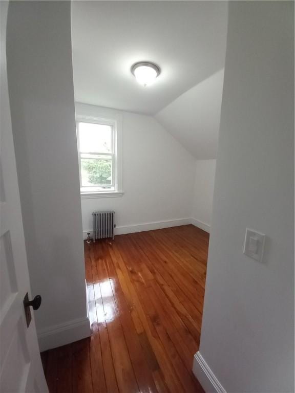 bonus room with lofted ceiling, radiator, wood-type flooring, and baseboards