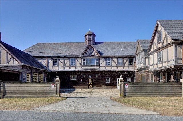 view of front of house with roof with shingles, a fenced front yard, and stucco siding