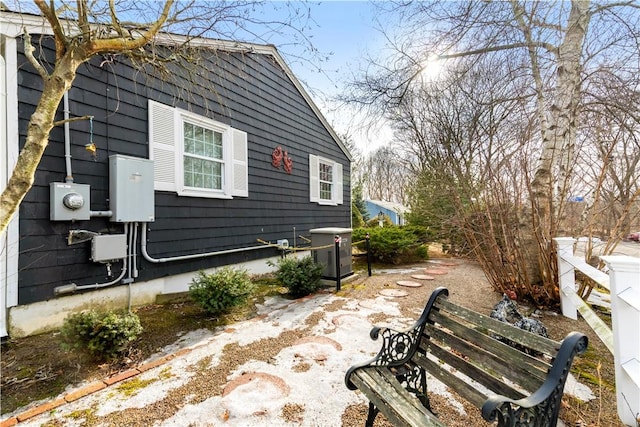 view of side of property with fence and central AC unit