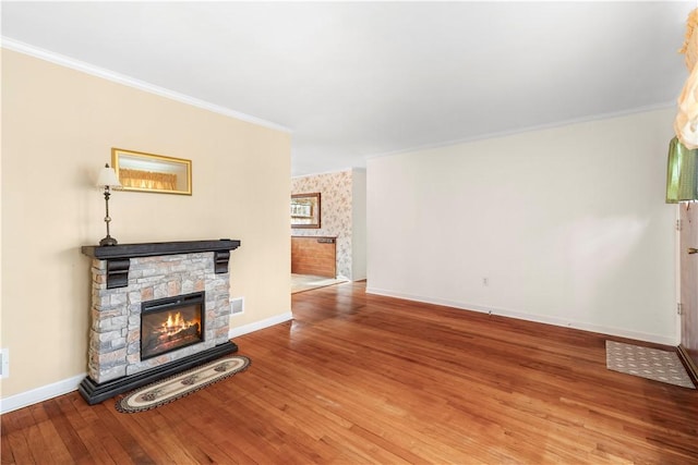 living room with ornamental molding, a fireplace, hardwood / wood-style floors, and baseboards