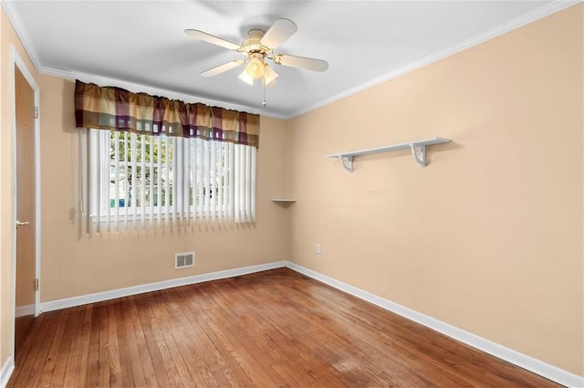 spare room featuring baseboards, hardwood / wood-style floors, and crown molding