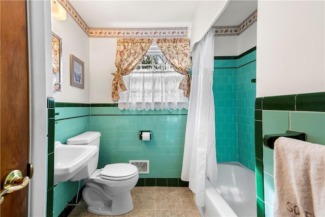 bathroom with tile walls, visible vents, toilet, wainscoting, and tile patterned flooring