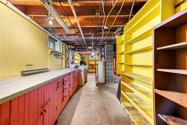 unfinished basement with water heater, washer / clothes dryer, and a workshop area