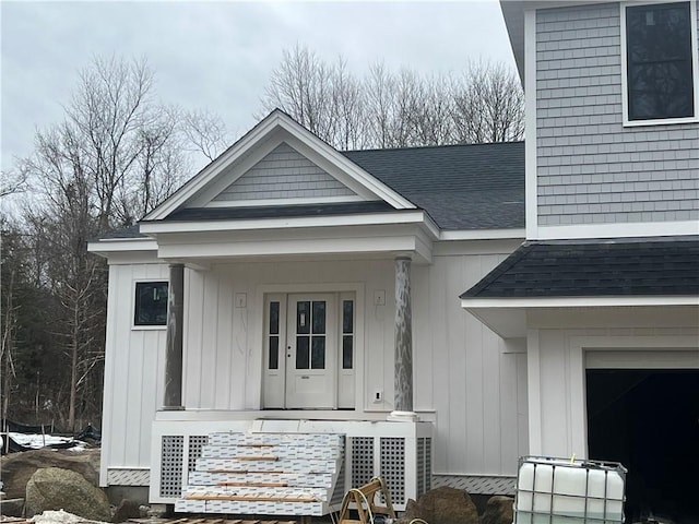 exterior space featuring a porch, roof with shingles, board and batten siding, and a garage