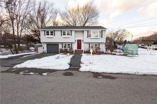 raised ranch with driveway and an attached garage