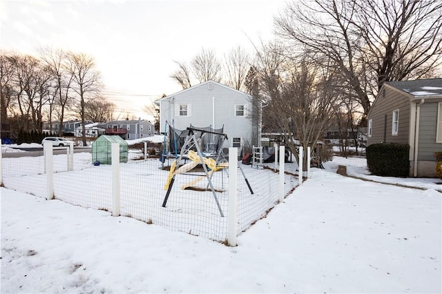 yard covered in snow with a trampoline