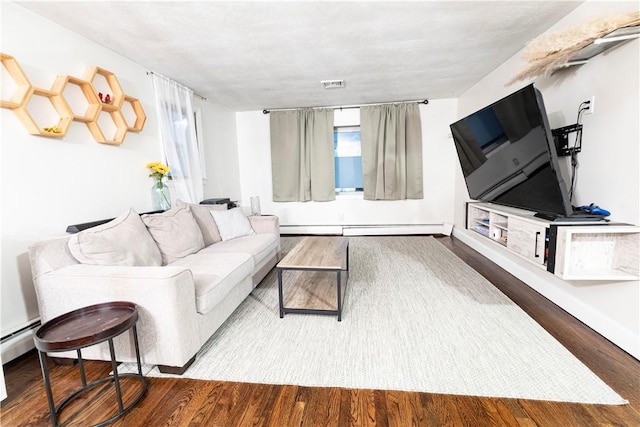 living area with visible vents, baseboard heating, and wood finished floors