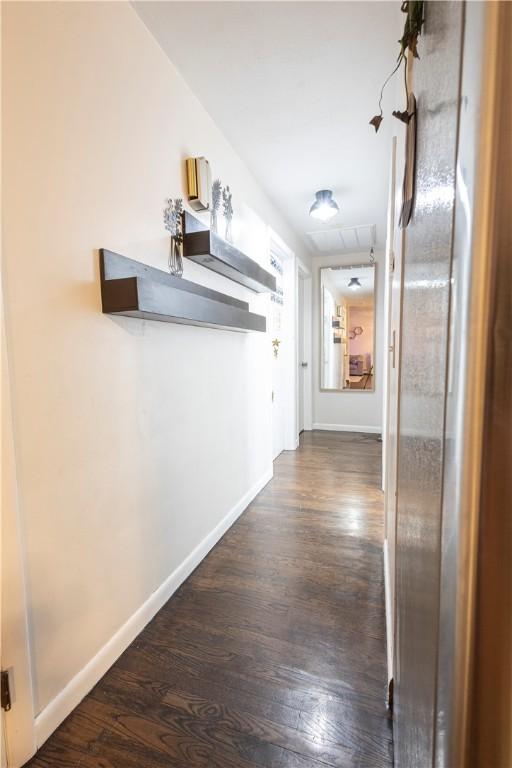 hallway featuring baseboards and wood finished floors