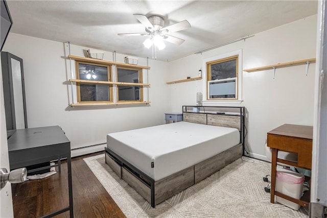 bedroom with a baseboard radiator, ceiling fan, and wood finished floors