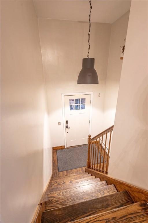 stairway with baseboards and wood finished floors