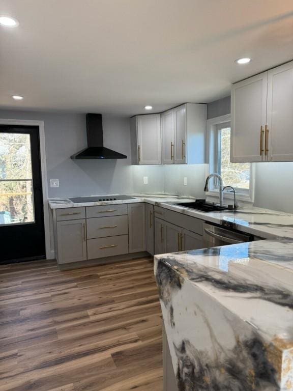 kitchen with gray cabinets, stainless steel dishwasher, a sink, wall chimney exhaust hood, and black electric cooktop