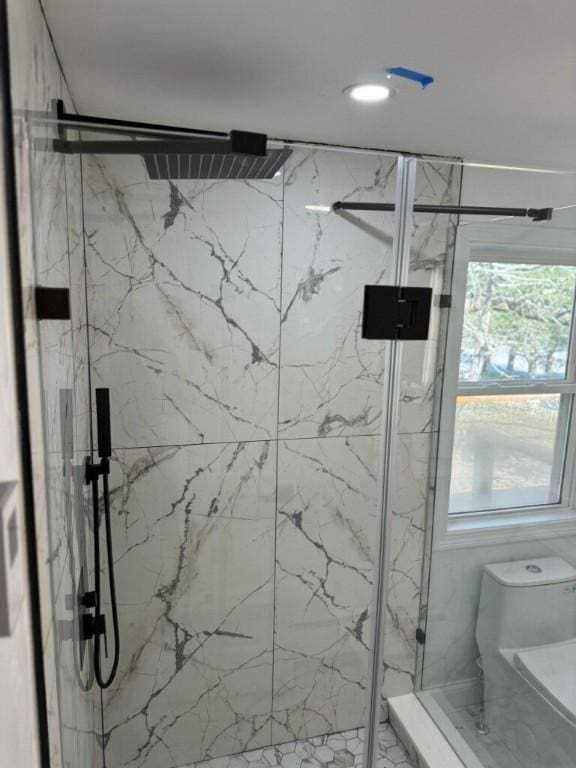 full bathroom with a marble finish shower and toilet