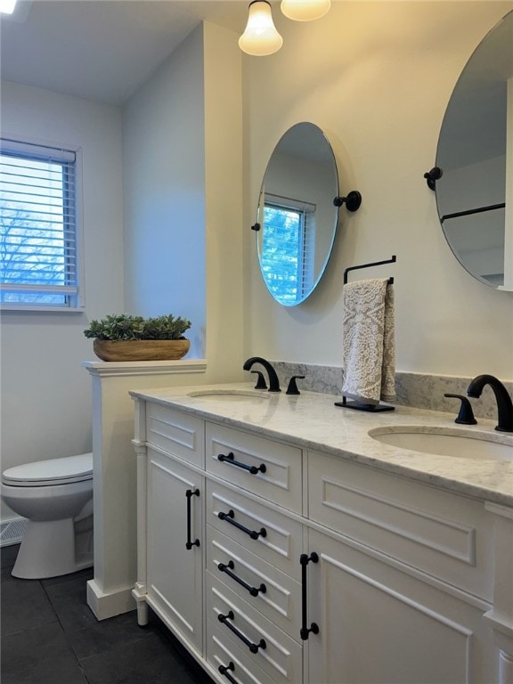 bathroom with a healthy amount of sunlight, a sink, and toilet