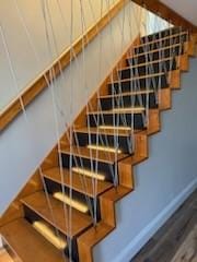 staircase featuring wood finished floors and baseboards