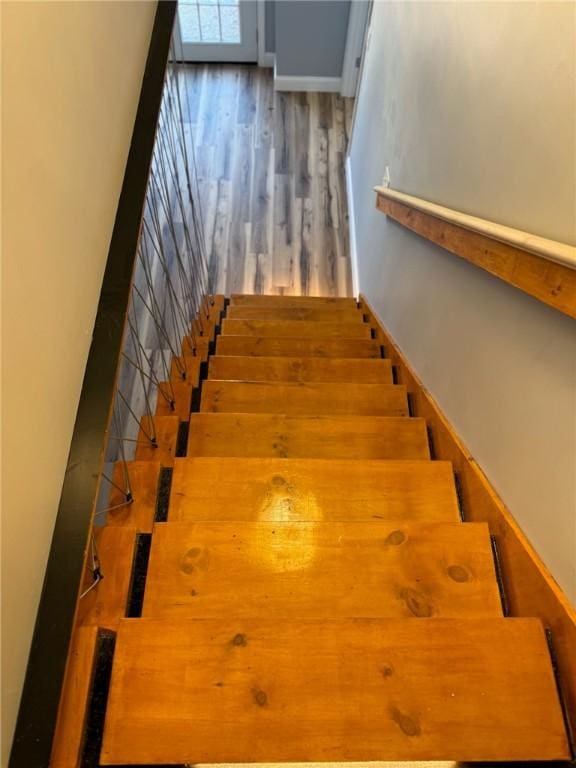 stairway featuring baseboards and wood finished floors