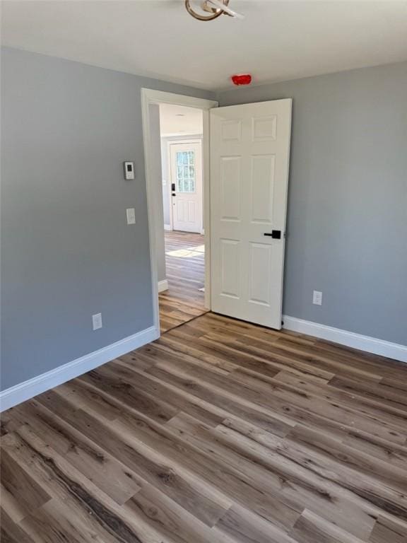 empty room featuring wood finished floors and baseboards