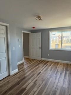 unfurnished bedroom with baseboards and wood finished floors