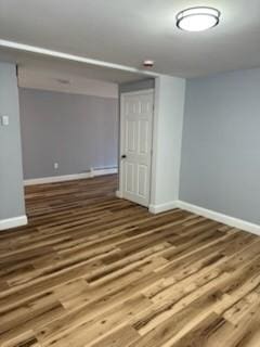 spare room with wood finished floors and baseboards