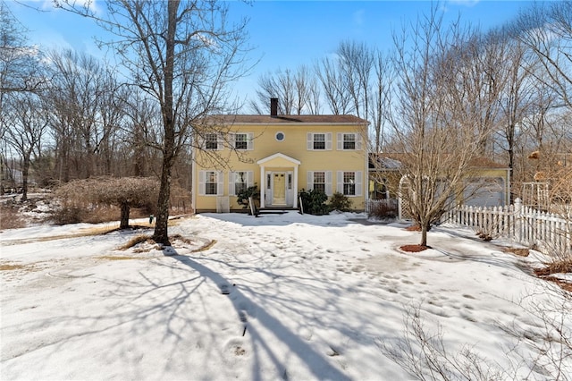 colonial-style house with fence and a chimney