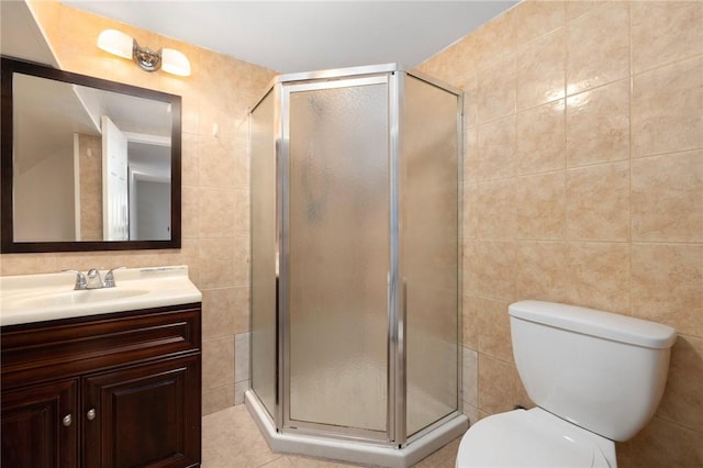 full bathroom with toilet, a shower stall, tile walls, and vanity