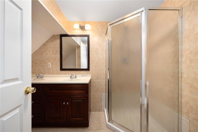 bathroom with tile walls, tile patterned floors, vanity, a shower stall, and backsplash