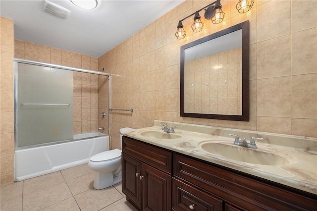 full bathroom with double vanity, a sink, tile walls, and tile patterned floors