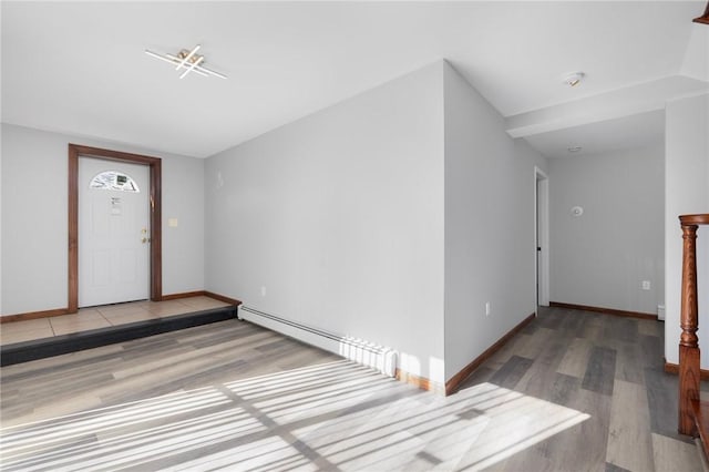 entryway featuring a baseboard heating unit, baseboards, and wood finished floors