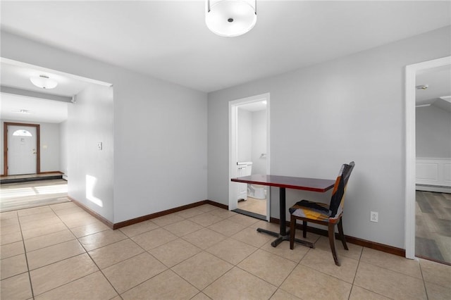 interior space with light tile patterned floors and baseboards