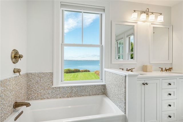 full bathroom featuring double vanity, a water view, a sink, and a bath