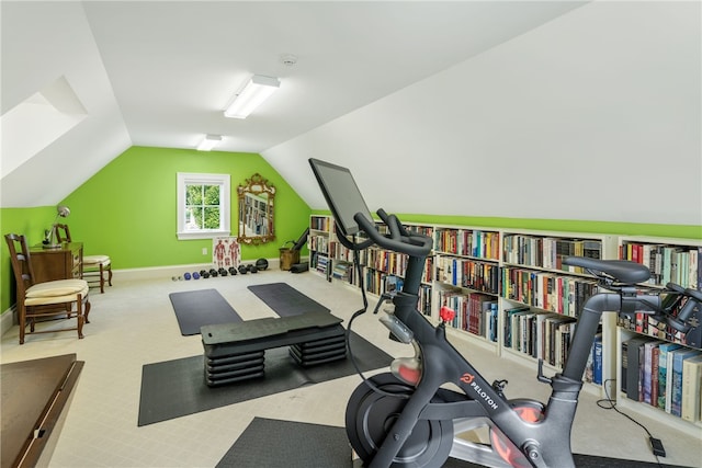 exercise room featuring vaulted ceiling, carpet floors, and baseboards