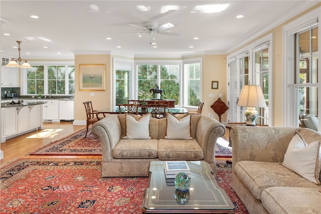 living area featuring light wood-style floors, recessed lighting, a ceiling fan, and crown molding