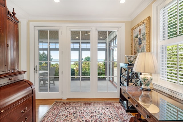 doorway to outside with light wood-style flooring and ornamental molding