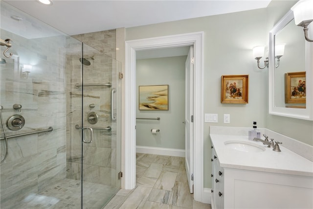 bathroom with a stall shower, vanity, and baseboards