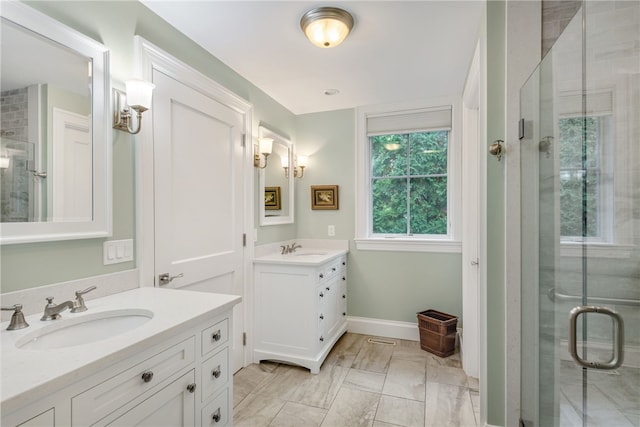 bathroom with a stall shower, two vanities, and a sink