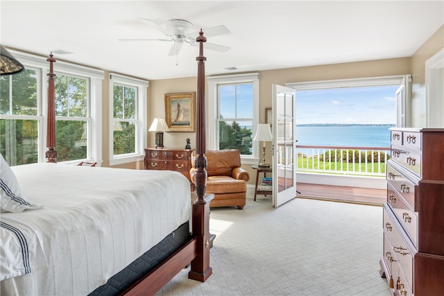 bedroom featuring multiple windows, a water view, visible vents, and ceiling fan