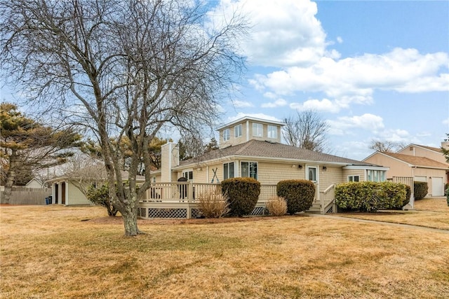 view of front of property featuring a front yard, a chimney, and a wooden deck