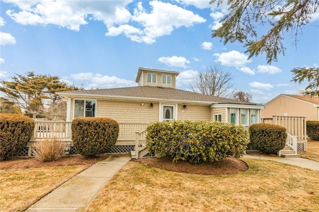 view of front of house featuring a front yard and a wooden deck