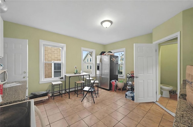 dining area with a baseboard radiator and light tile patterned floors