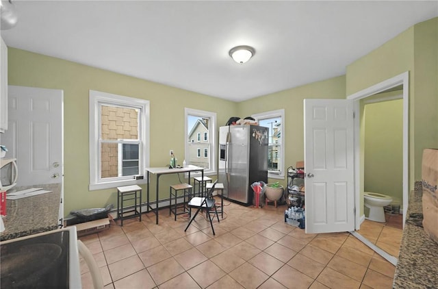 interior space featuring a baseboard heating unit and light tile patterned floors