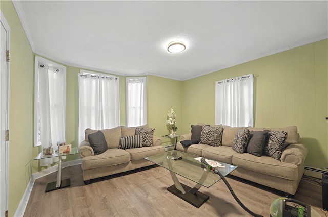 living room with visible vents, baseboard heating, ornamental molding, a baseboard heating unit, and wood finished floors