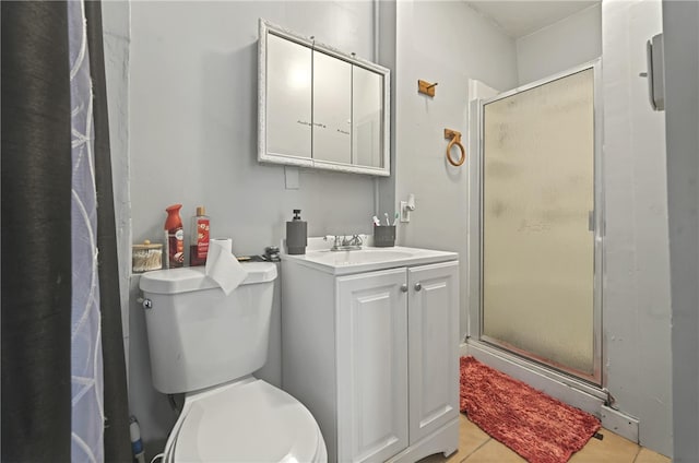 bathroom featuring vanity, toilet, a stall shower, and tile patterned floors