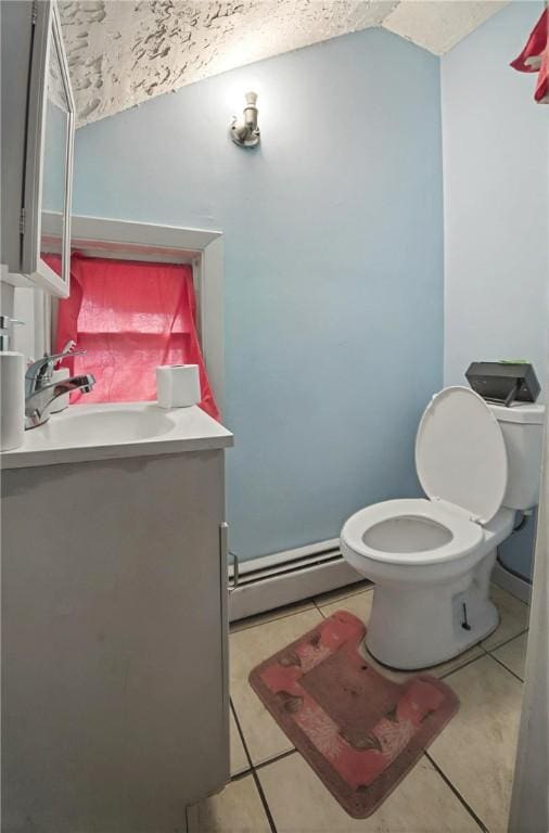 bathroom with a baseboard heating unit, tile patterned floors, vanity, and toilet