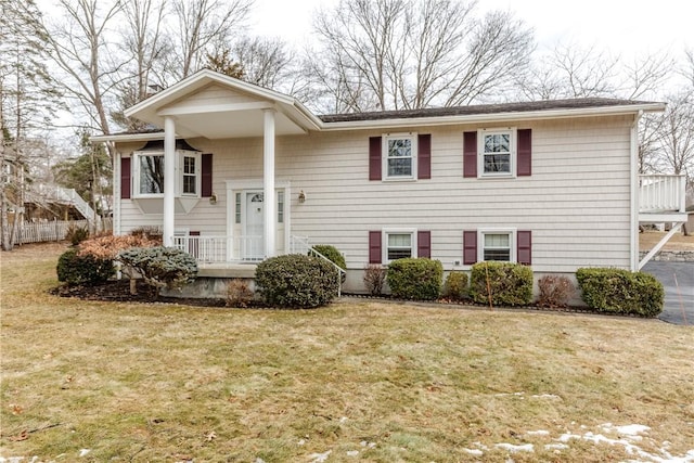 split foyer home with fence and a front lawn