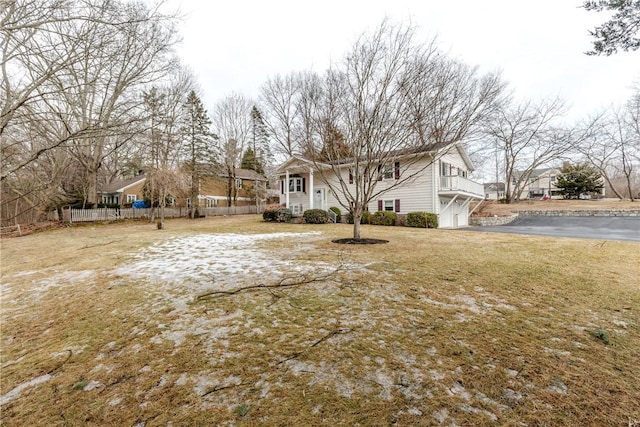 exterior space featuring a garage, driveway, fence, and a lawn