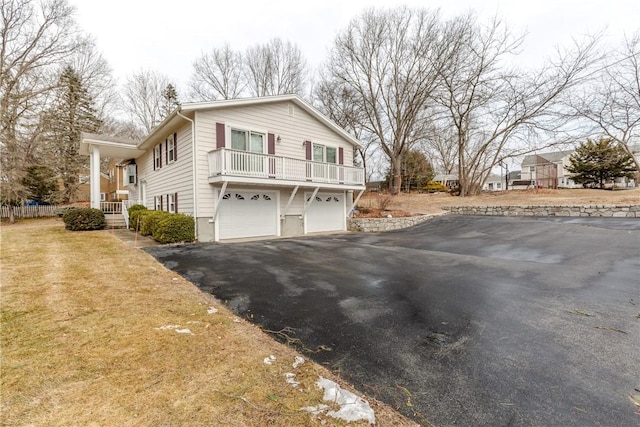 view of side of property with aphalt driveway, a yard, and an attached garage